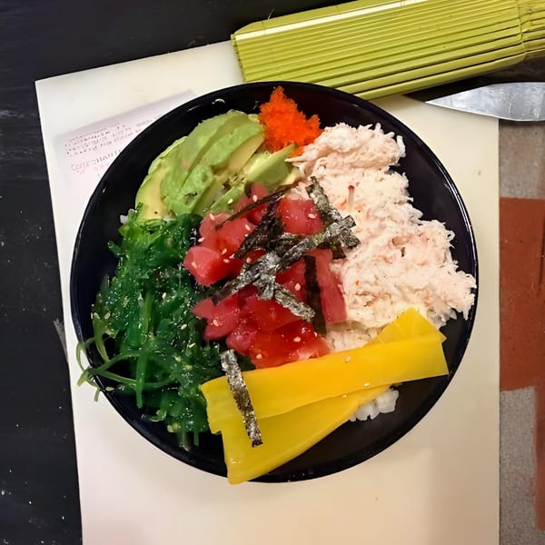 Ahi Sushi & Grill poke bowl with tuna, avocado, crab, seaweed salad, and yellow daikon.